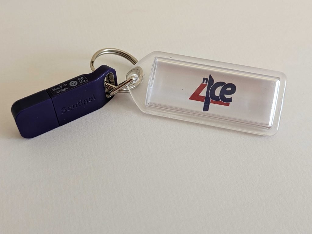 A keyring containing the n4ce logo, attached to a purple USB dongle